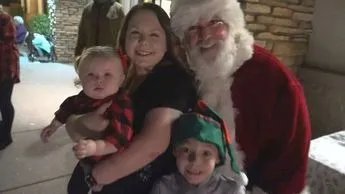 A man in a santa suit and two children