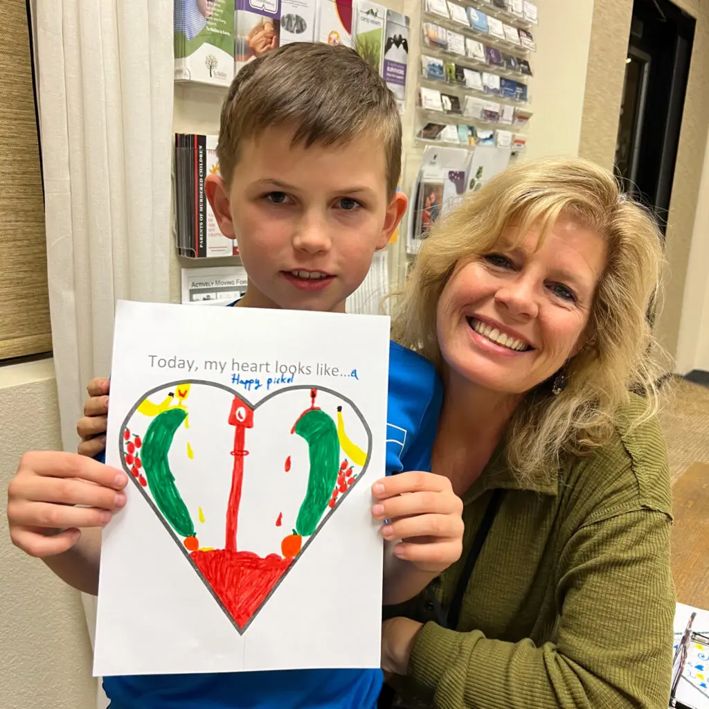 Woman and boy with picture of colorful heart